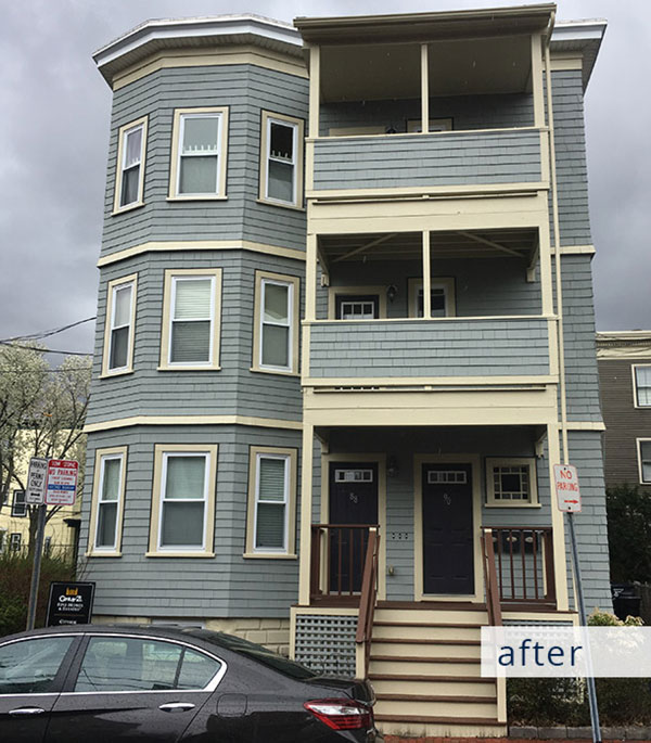 A gray building with a sign on it.